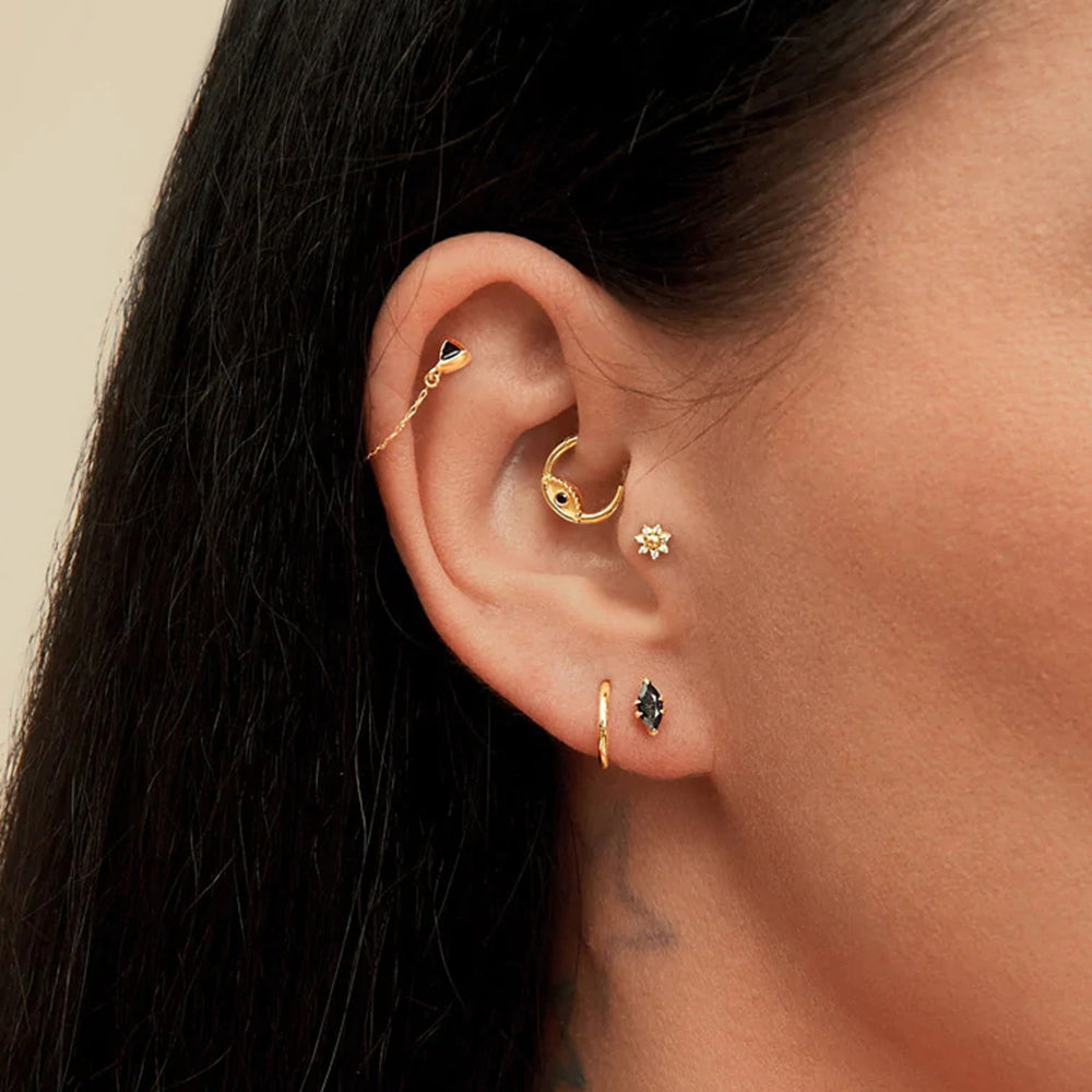 El piercing de oreja aro ojo de Zuri siendo usado, ilustrando cómo añade un toque de misterio a cualquier look piercing daith