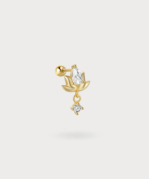 Piercing Miriam con forma de loto dorado, iluminado por un colgante de circonitas.