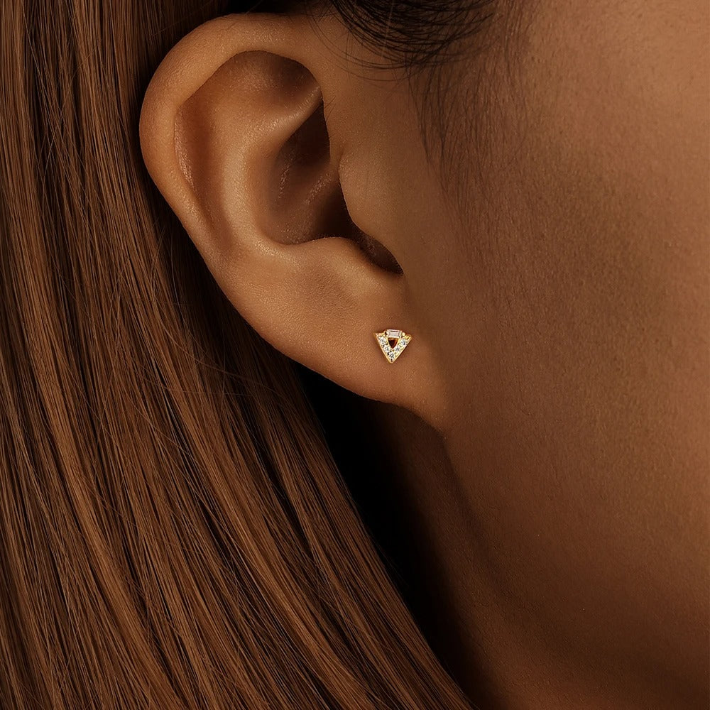Mujer llevando el piercing Auxi en el lóbulo en oro, también disponible para el flat.