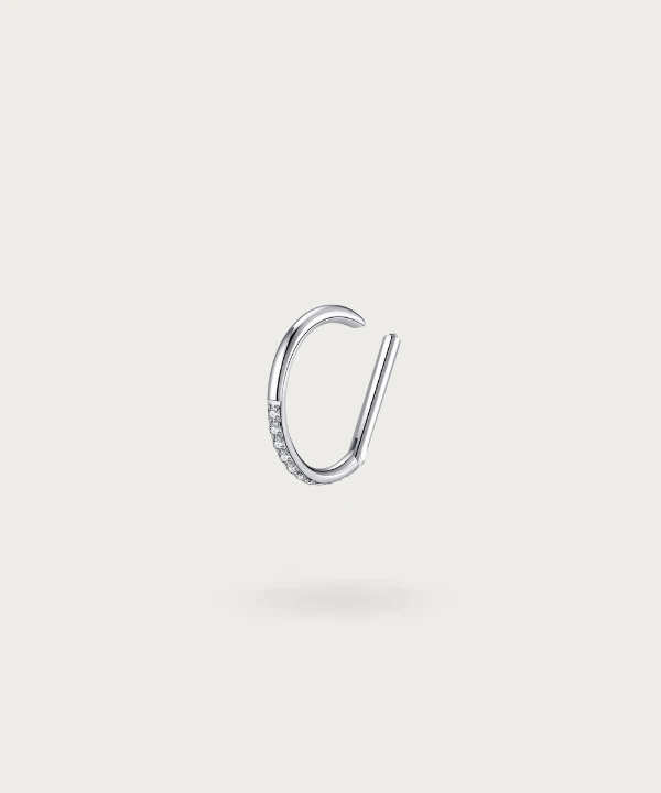 Detalle del piercing hélix Alicia, mostrando su diseño de herradura con circonitas y el seguro cierre en titanio