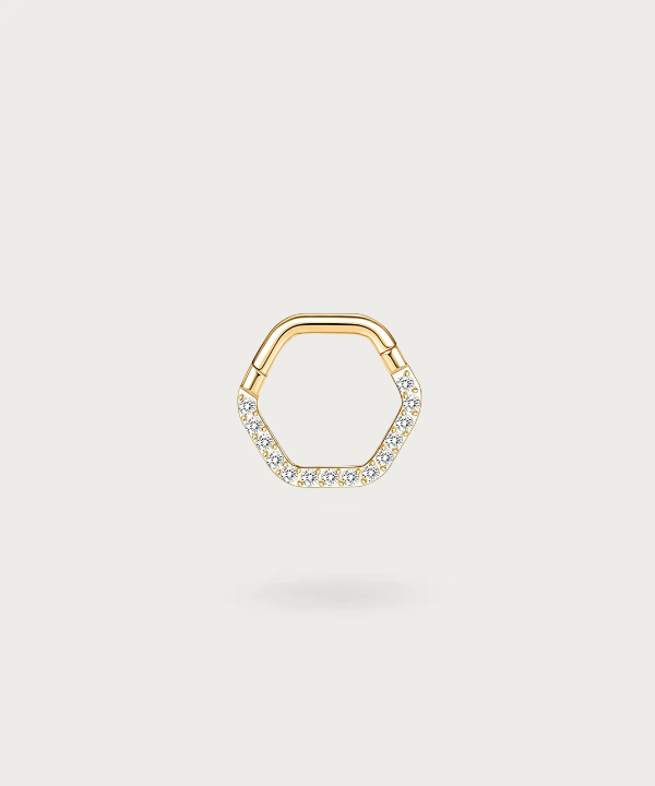 Moderno y elegante piercing daith Alicia de titanio con circonitas en forma de hexágono, destacando sobre un fondo oscuro