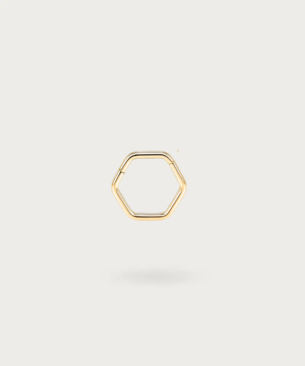 Piercing de hélix Erica en titanio con diseño geométrico, destacando sobre un fondo oscuro
