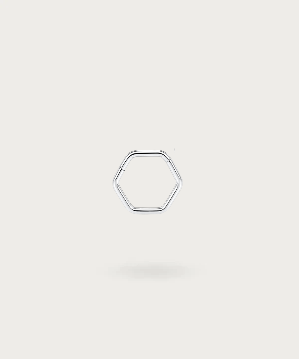 Primer plano del piercing daith Erica, mostrando su diseño geométrico hexagonal y el acabado en titanio