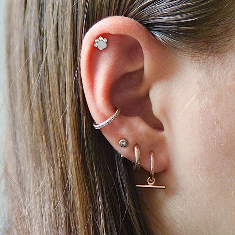 mujer con piercing plata pata de perro al helix