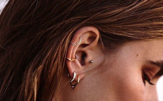 mujer con piercings en la oreja