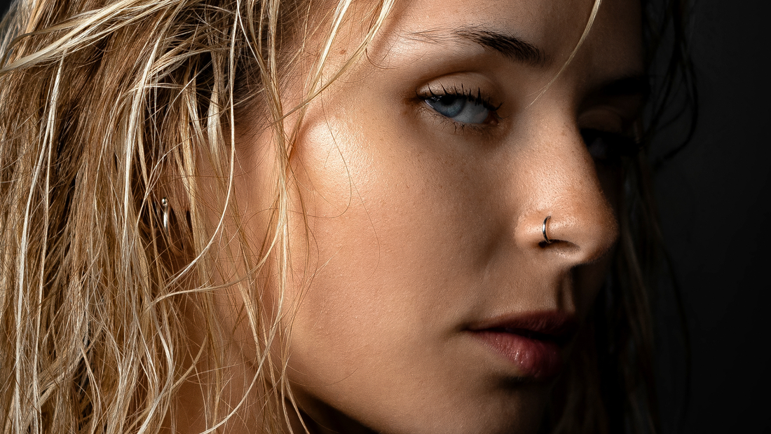 Mujer con cara ovalada y piercings en las orejas