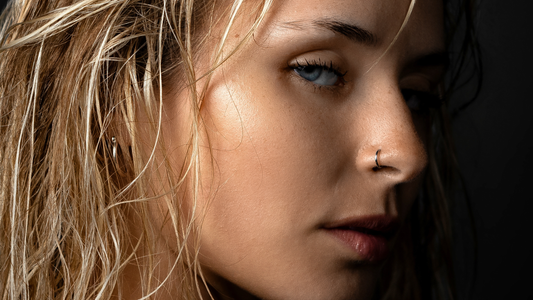 Mujer con cara ovalada y piercings en las orejas