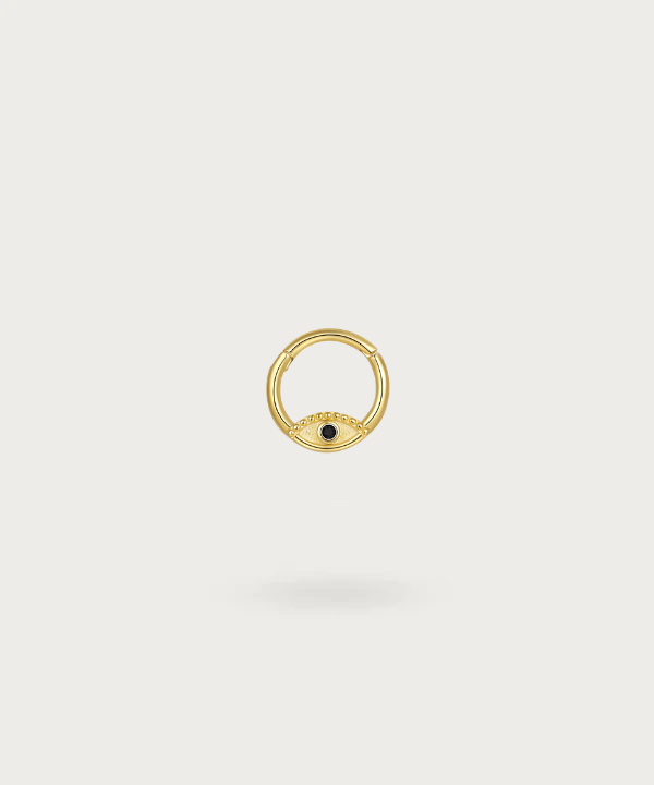 "Primer plano del piercing de oreja aro ojo de Zuri en plata 925 bañada en oro, mostrando el detalle del diseño del ojo piercing helix