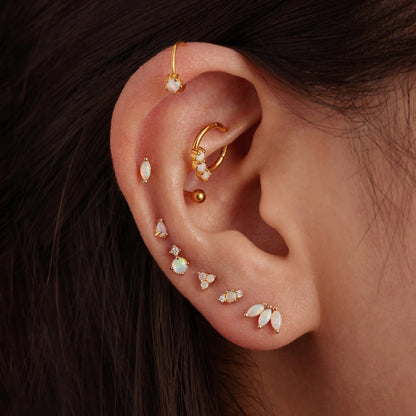 mujer con piercings de oreja de opalo en su oreja